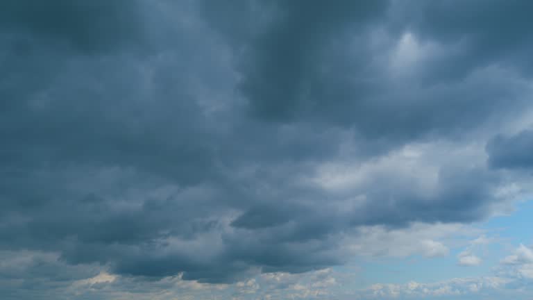 Cumulus clouds moves in the blue sky. Dark huge cloud in sky. Change of weather. Time lapse.