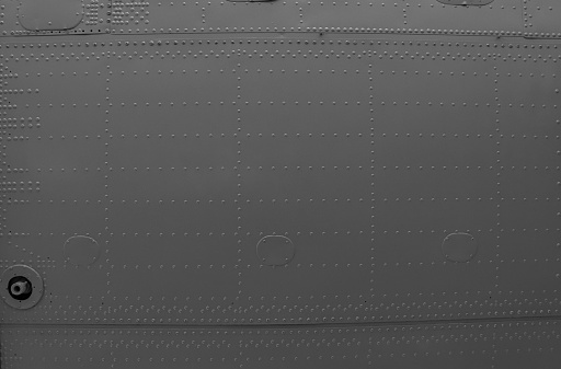 Aircraft skin close up. Rivets on gray metal. Background for design.