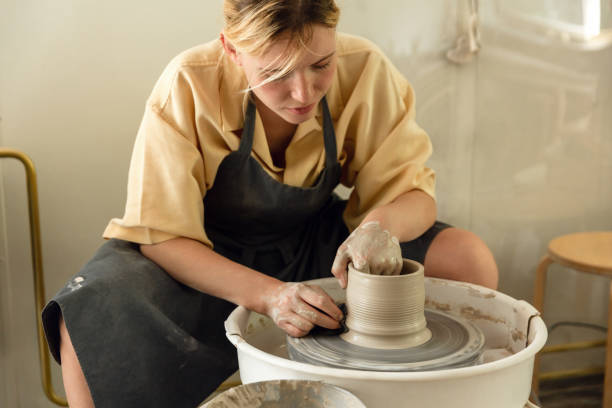 도공의 바퀴에 도자기 화병을 만드는 여성 도공 - shaping clay 뉴스 사진 이미지