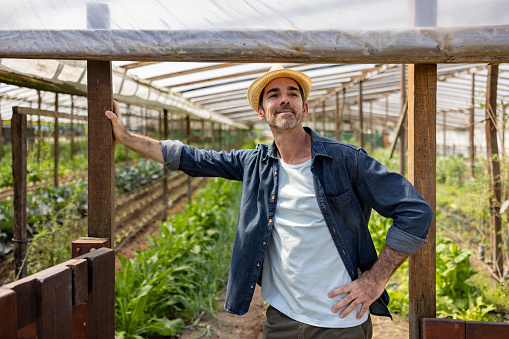 Happy Latin American man looking proud of his vegetable garden - sustainable lifestyle concepts