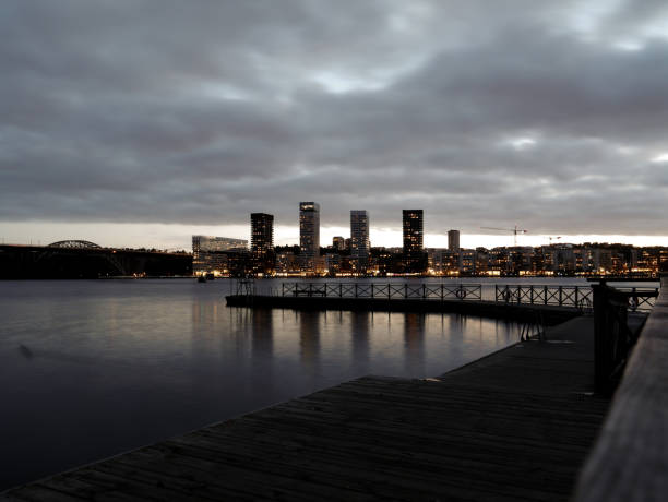 View of buildings by river against cloudy sky
