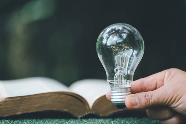 istock Book or textbook with glowing light bulb. Self learning or education knowledge and business studying concept. Idea of learning or studying at home. technology, Create Imagination for Inspiration. 1441159079