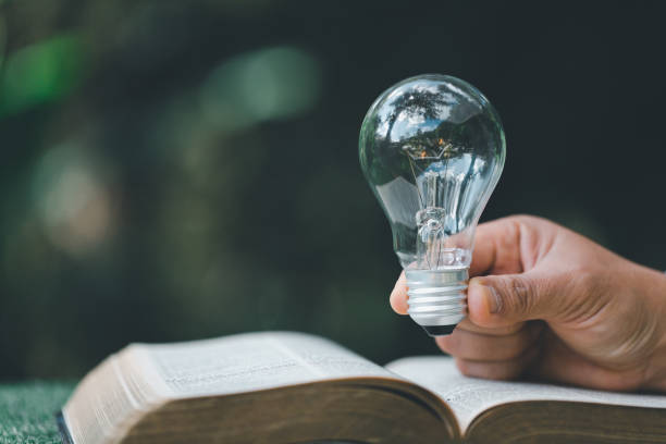 istock Book or textbook with glowing light bulb. Self learning or education knowledge and business studying concept. Idea of learning or studying at home. technology, Create Imagination for Inspiration. 1441159098
