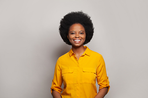 Happy woman in yellow shirt smiling, portrait