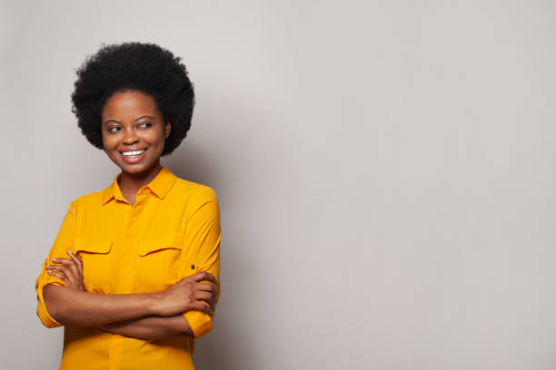 istock Cheerful woman with curly hair looking aside at copy space on white studio background 1441159255