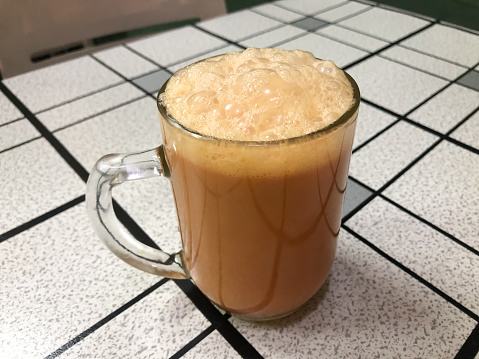 Tea with milk or popularly known as Teh Tarik in a mug on the table