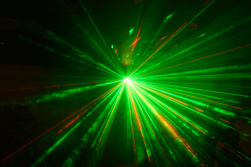 green and red laser beams on a black background