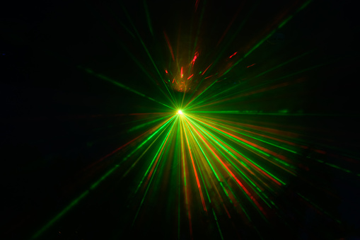 green and red laser beams on a black background