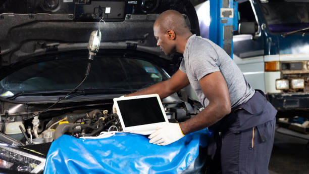 istock Professional car mechanic repair service and checking car engine by Diagnostics Software computer. Expertise mechanic working in automobile repair garage. 1441162566