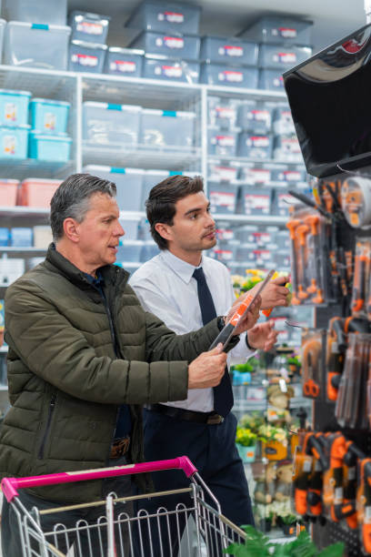 istock Store clerk helps his customer find the tools he is looking for in the store 1441165033
