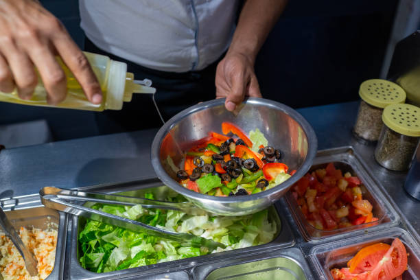 istock Chef preparing a stainless steel bowl with assorted salad with salad ingredients 1441165230
