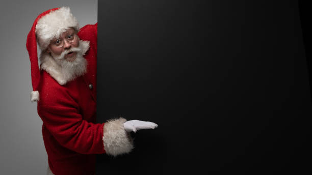 istock Santa Claus pointing black billboard 1441166654
