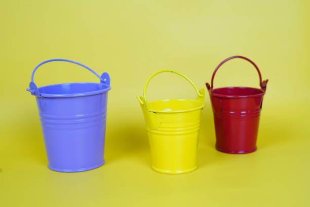 istock Buckets of different sizes isolated on a yellow background 1441170427