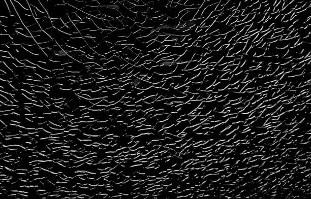 istock Broken glass with white cracks. Abstract cracked window on black. 1441170782