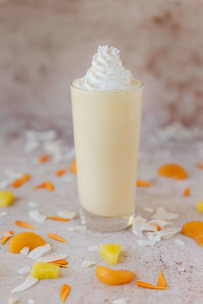 istock Selective focus vertical closeup of an Orange Coconut Shake on a marble surface 1441171300