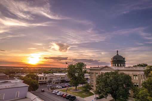 The architecture of Courthouse in Georgetown, Texas with street view, cars, greenery at sunset
