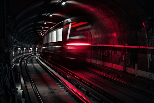 Montreal, Canada – August 06, 2022: A long exposure of a train driving underground illuminated by red lights. Montreal, Canada