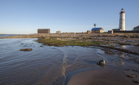 Peaceful sea shoreline with the Vilsandi Lighthouse in the background