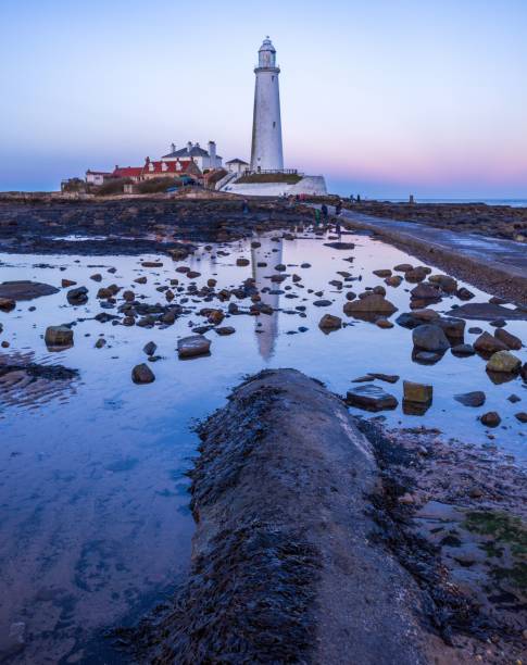 istock Vertical shot of a lighthouse reflected on the water during the sunset 1441174157