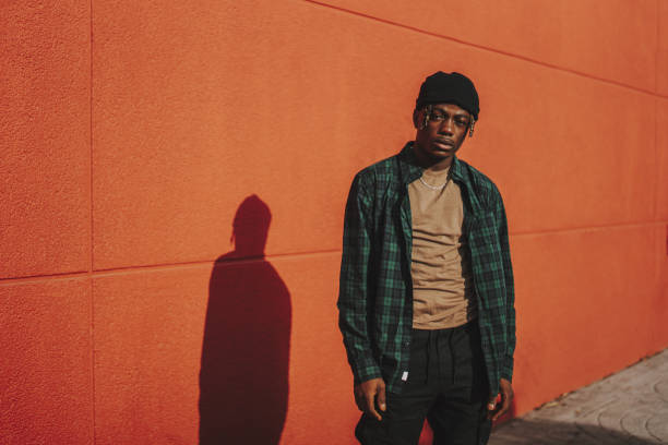 istock Handsome stylish Spanish man posing on a red wall background on a sunny day 1441174362