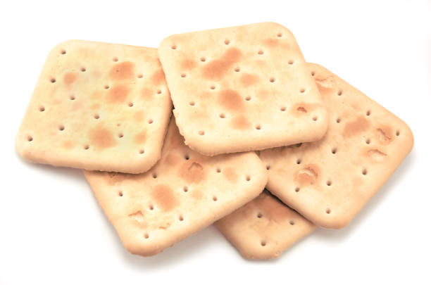 istock Soda cracker stack closeup, large detailed isolated square crisp whole grain saltine crackers macro closeup, military field ration MRE concept, gentle shadows, perforations, saltines flat lay detail studio shot, blank empty horizontal white background cop 1441176044