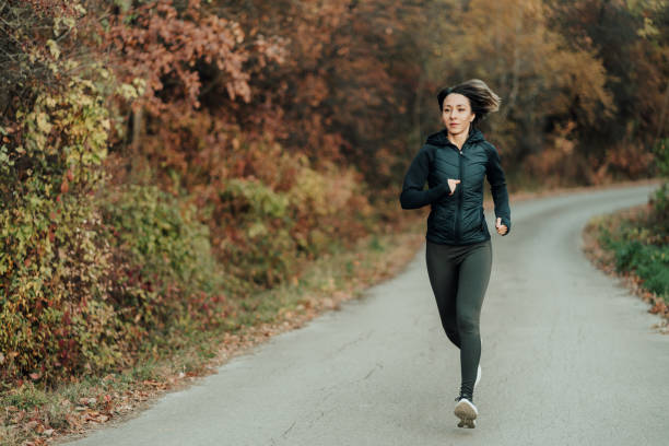 istock Young woman jogging in the forest 1441176100