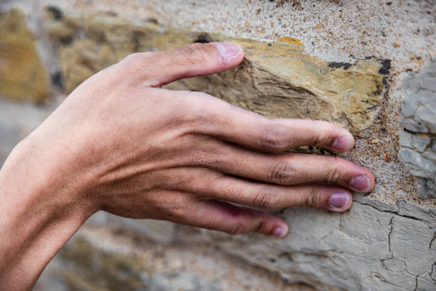 istock Closeup of a hand touching a weathered stone surface 1441176526