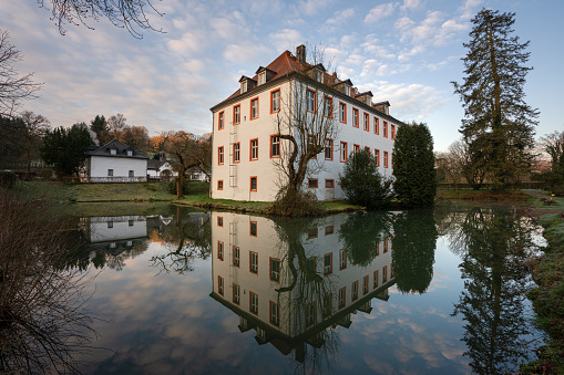 Lindlar, Germany – April 15, 2021: Castle Georghausen close to Lindlar with water reflection at evening hours, Bergisches Land, Germany