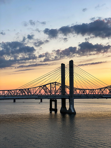 A golden mesmerizing sunset over the Ohio River at Waterfront Park Louisville, USA-vertical shot