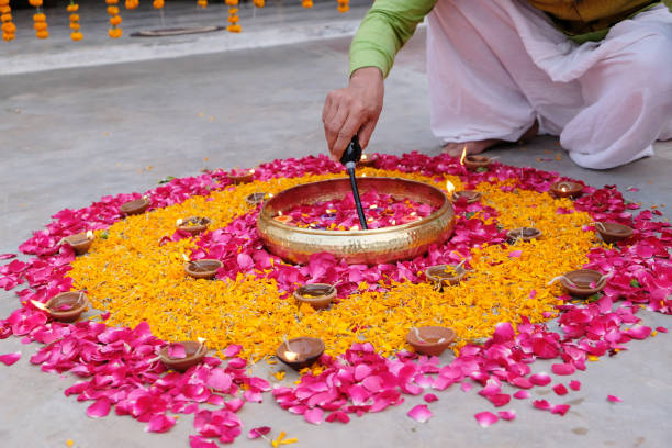istock Man's hand lights a candle while creating rangoli on the ground 1441179626