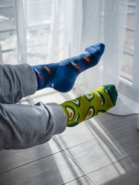 istock Two different artistic socks on feet, with avocados on the left and blue space on the right 1441179863