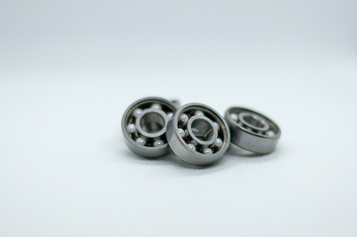 A closeup shot of isolated ceramic ball bearings in a pile on a grey background
