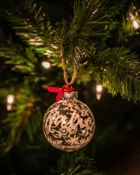 A vertical shot of a Christmas tree decoration ball with a writte name "Katie"