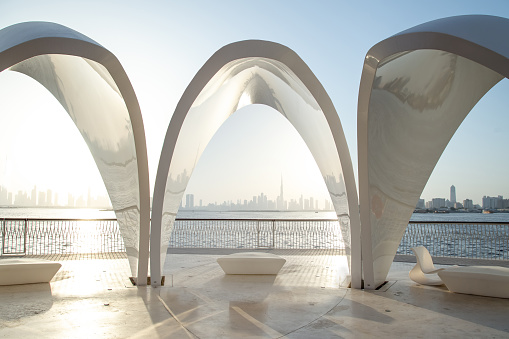Dubai Creek Harbour arches at sunset with city and Khalifa at the back