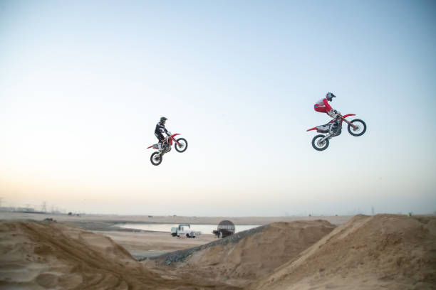A motorcyclist speeds along the sandy seashore.