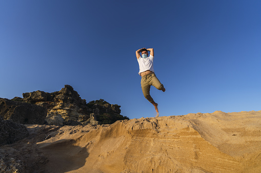 A positive picture of a jumping man in a steppe with mask