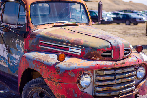 The closeup of the old red truck in a junkyard