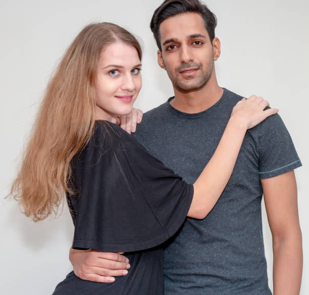 istock Attractive interracial couple is posing in the light gray background 1441181487