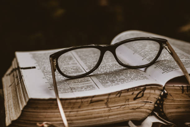 istock Selective focus shot of glasses on an old book 1441183499