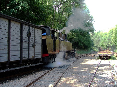 An old steam train stopped in a small station awaits the moment of departure
