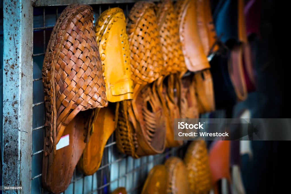 Traditional footwear from Kolhapur, India, Kolhapuri Traditional footwear from Kolhapur, India, Kolhapuri Chappal showcasing on white wall Art Stock Photo