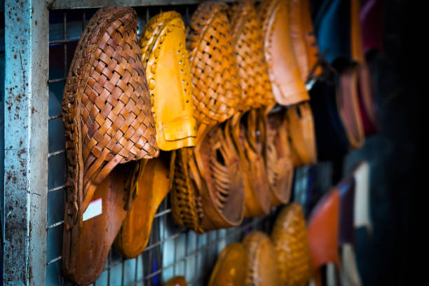 Traditional footwear from Kolhapur, India, Kolhapuri Traditional footwear from Kolhapur, India, Kolhapuri Chappal showcasing on white wall handmade indian shoes on white stock pictures, royalty-free photos & images