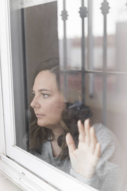 istock woman looking out the window 1441184973