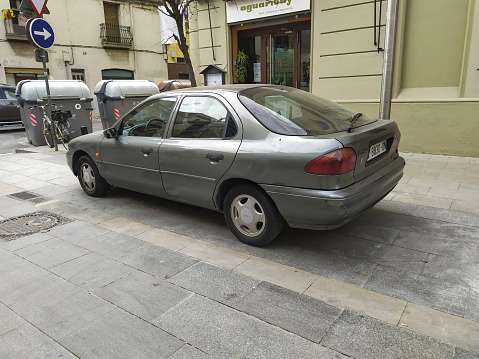 Barcelona, Spain – April 27, 2021: Barcelona, Spain; March 5, 2021: Old gray Ford Mondeo MK1 parked in the street, it is a saloon from the 90s