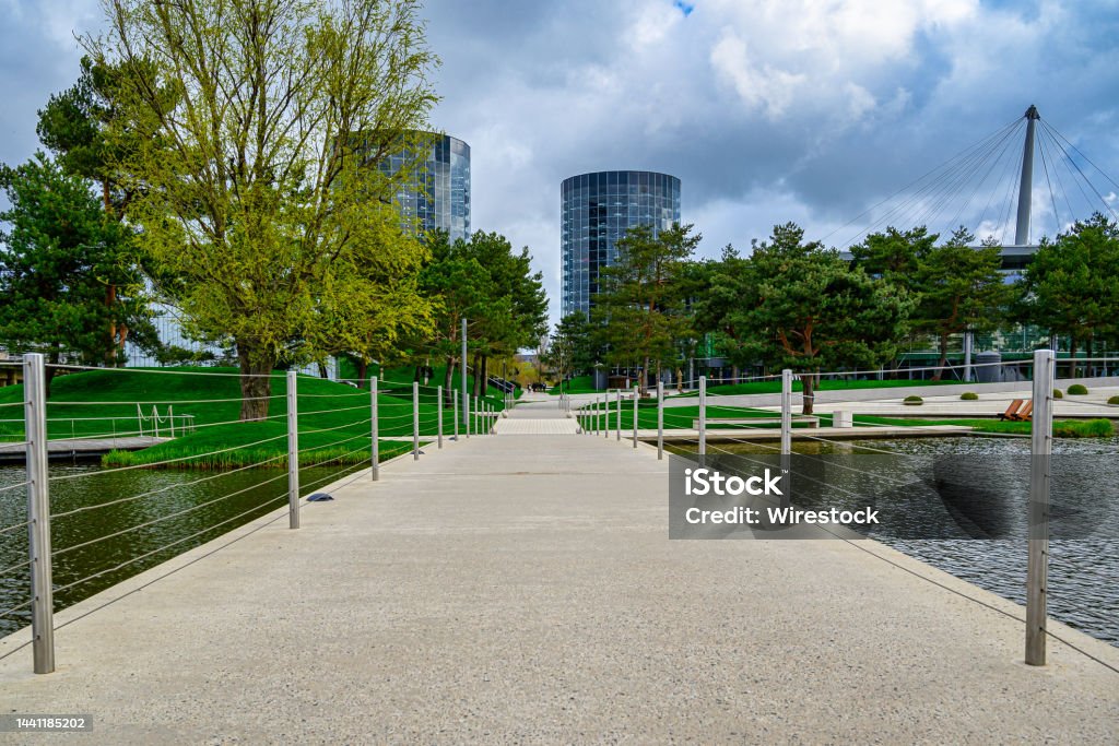 Beautiful footbridge over a calm lake in the green Autostadt park in Wolfsburg, Germany A beautiful footbridge over a calm lake in the green Autostadt park in Wolfsburg, Germany Wolfsburg - Lower Saxony Stock Photo