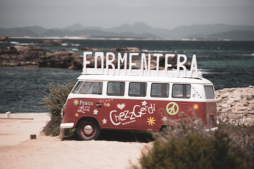 Es Pujols, Spain – May 29, 2021: Formentera, Spain: 2021 May 29: Classic German Volkswagen Transporter van on Es Pujols beach in Formentera in the summer of 2021