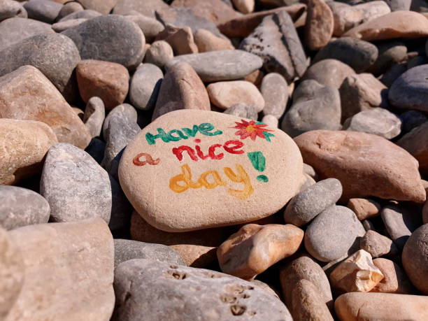 A closeup shot of a flat pebble with a colorful message \