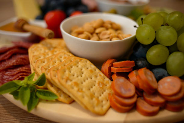 istock Platter of tasty snacks: cheese, crackers, honey, fruit, and nuts 1441187350