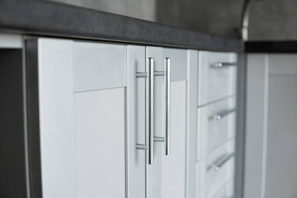 Modern minimalist style kitchen close up in monochrome tones. Custom kitchen with grey white facades mdf and dark grey countertop. Modular kitchen from chipboard. stock photo