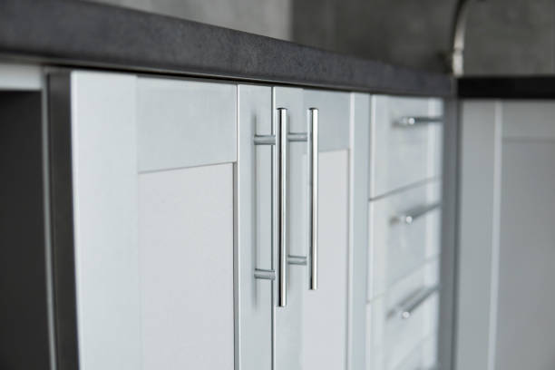 Modern minimalist style kitchen close up in monochrome tones. Custom kitchen with grey white facades mdf and dark grey countertop. Modular kitchen from chipboard. Modern minimalist style kitchen close up in monochrome tones. Custom kitchen with grey white facades mdf and dark grey countertop. Modular kitchen from chipboard modular kitchen stock pictures, royalty-free photos & images